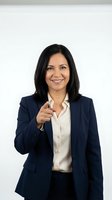 Confident Hispanic businesswoman in navy suit pointing at camera with friendly smile on white background for corporate marketing materials.