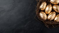 Golden Easter eggs in rustic nest on dark slate background with copy space. Festive spring holiday composition for seasonal greeting cards.