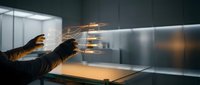 Professional chef cooking in modern commercial kitchen with dramatic flames and motion blur creating dynamic culinary atmosphere for restaurant industry.