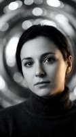 Young Caucasian woman in turtleneck sweater with dramatic lighting and bokeh background for creative portrait photography and artistic projects.