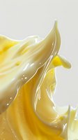 Smooth flowing yellow cream or honey abstract splash with silky texture and glossy surface against light background, dynamic liquid motion captured in detail.
