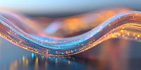 Abstract glowing wave with luminous particles and light trails against blurred background, creating dynamic flowing motion effect in orange and blue tones.