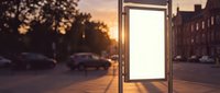 Blank white billboard advertisement display on city street during golden hour sunset with urban background and warm lighting for marketing mockup.