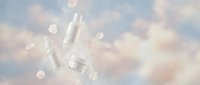 Cosmetic skincare bottles and jar with dropper displayed against soft bokeh background with light particles, suitable for beauty and wellness marketing.