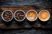 Four white cups showing coffee progression from roasted beans to fresh brewed espresso on rustic wooden background for cafe menu design.