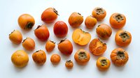 Medlar fruits in various sizes and stages of ripeness arranged on white background, suitable for food photography, culinary content, and agricultural stock imagery.