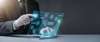 Businessman using laptop with digital holographic interface displaying business analytics, financial data and growth charts for modern technology solutions.