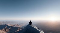 Person sitting on mountain peak enjoying sunrise view over vast landscape with rolling hills and valleys stretching to horizon under clear morning sky.