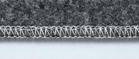Professional overlock serger stitch on gray fabric edge showing white thread construction and textile finishing technique for garment manufacturing.