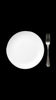 Empty white ceramic plate with silver fork isolated on transparent background, ready for dining, restaurant, menu design, t-shirt graphics, clipart, and print-on-demand projects.