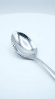 Shiny stainless steel soup spoon isolated on white background for kitchen utensil and dining concepts.