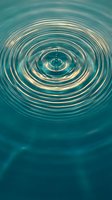 Water drop creating concentric ripples on turquoise surface with golden reflections. Abstract liquid motion capturing peaceful zen moment for meditation concepts.