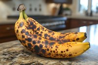 Overripe spotted bananas on kitchen counter ready for baking bread or smoothies in modern home interior.
