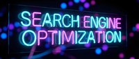 Neon sign displaying search engine optimization text in bright blue and pink colors against dark background with bokeh lights for digital marketing.