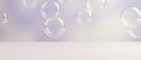 Floating soap bubbles against soft purple and white gradient background creating dreamy atmosphere for relaxation and wellness concepts.