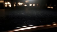 Dark marble surface with warm bokeh lights creating elegant restaurant or kitchen counter backdrop for product display and commercial photography.