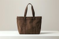 Brown canvas tote bag with leather handles on neutral background, minimalist design for everyday use and shopping, durable fabric texture and classic style.