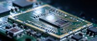 Close-up macro view of computer processor chip and circuit board with intricate electronic components, microchips, and green PCB technology hardware.
