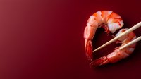 Fresh cooked pink shrimp held with wooden chopsticks on dark red background, minimalist food composition for restaurant menu and seafood advertising.