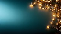 Glowing fairy lights creating magical border on dark turquoise background with copy space, festive holiday season decoration for greeting cards and banners.