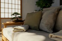 Minimalist Japanese living room interior with gray sofa, decorative bonsai tree and shoji screen window creating zen atmosphere for peaceful home design.