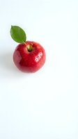 Fresh red apple with green leaf isolated on white background for healthy eating and nutrition concepts.