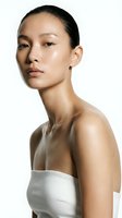 Young East Asian woman with glowing, radiant skin showcasing skincare, cosmetics, and wellness products. Minimal makeup aesthetic for beauty, dermatology, and spa industry use.