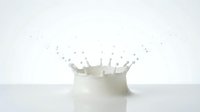 Milk splash crown formation with droplets frozen in motion against clean white background for dairy and beverage advertising concepts.