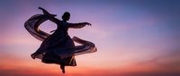Silhouette of graceful female dancer in flowing dress against dramatic sunset sky with purple and orange hues. Movement and freedom concept for wellness and arts.