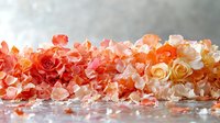 Fresh coral and peach roses with scattered petals creating romantic composition on reflective surface with soft bokeh background, suitable for wedding design.