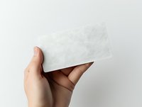 Caucasian hand holding blank white card or paper against neutral background, suitable for mockups, branding, and design presentations.
