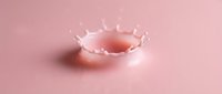 Liquid splash crown forming in pink fluid against soft pastel background, suitable for cosmetics, skincare, and beverage product marketing.