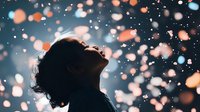 Young Asian woman with curly hair in profile looking up at falling bokeh lights against dark background, dreamy atmospheric night portrait with glowing particles.