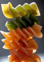 Colorful stacked fruit jelly candies in yellow, green and orange shades against dark background, macro photography showing sugar coating and translucent texture.