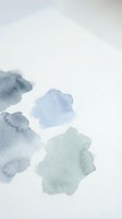 Abstract watercolor paint blobs in blue and green tones on white paper background for artistic design projects and creative layouts.