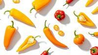 Colorful hot chili peppers scattered on white background. Fresh spicy vegetables for cooking, seasoning and culinary ingredients in kitchen preparation.
