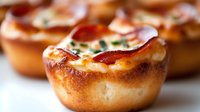 Golden baked Yorkshire pudding cups filled with crispy bacon and fresh herbs, traditional British comfort food for Sunday roast dinners and holidays.