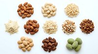 Assorted nuts and seeds including almonds, cashews, peanuts, and pistachios arranged on white background for food, nutrition, and healthy eating concepts.