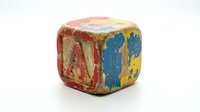 Vintage wooden alphabet block with weathered paint and letters isolated on white background for educational toys and nostalgic childhood memories.