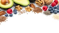 Healthy superfood ingredients with nuts, berries, avocado and seeds arranged on white background with copy space for nutritious eating concepts.