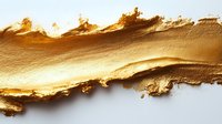 Golden makeup foundation smear with textured brush strokes on white background for cosmetic and beauty product advertising campaigns.