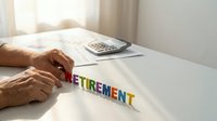 Senior hands arranging colorful wooden letters spelling RETIREMENT on white desk with calculator and documents for financial planning concept.