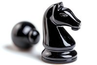 Black chess knight piece with glossy finish on white background, selective focus on horse head with blurred pawn in background, strategic game concept.