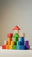 Colorful wooden building blocks stacked in tower formation with red roof, featuring rainbow hues for children's educational play and creative development activities.