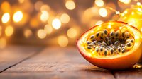 Fresh cut passion fruit on wooden surface with golden bokeh lights in background creating warm atmospheric mood for food photography and design.