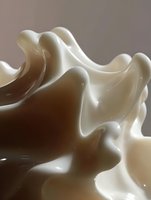 Smooth flowing waves of chocolate and cream creating abstract fluid shapes with soft shadows and highlights, suitable for food industry advertising and packaging design.