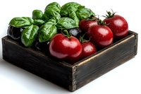 Fresh red tomatoes and green basil leaves arranged in rustic wooden box against white background, dramatic lighting highlights produce freshness.