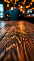 Wooden table surface in close-up with warm golden bokeh lights blurred in background, creating cozy atmosphere for hospitality, restaurant, or interior design projects.