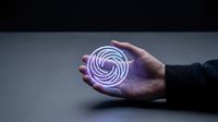 Person holding glowing purple spiral neon light orb in palm against dark background, representing innovation, technology, energy, and futuristic concepts for design projects.