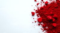 Vibrant red powder pigment scattered and spilled on white background, creating dynamic texture and contrast. Suitable for cosmetic, art and food industry visuals.